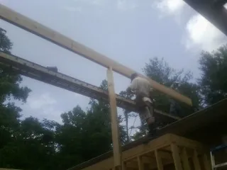 Carpenter setting a ridge beam over a new addition frame — Ice Dam Removal by Roofing Brothers in Black River Falls
