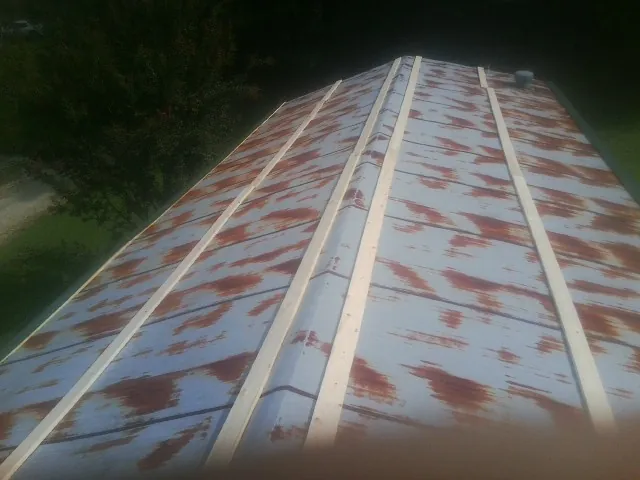 Rusted metal roof panels with new wood purlins before replacement — Storm Damage Roof Repair in Black River Falls by Roofing Brothers
