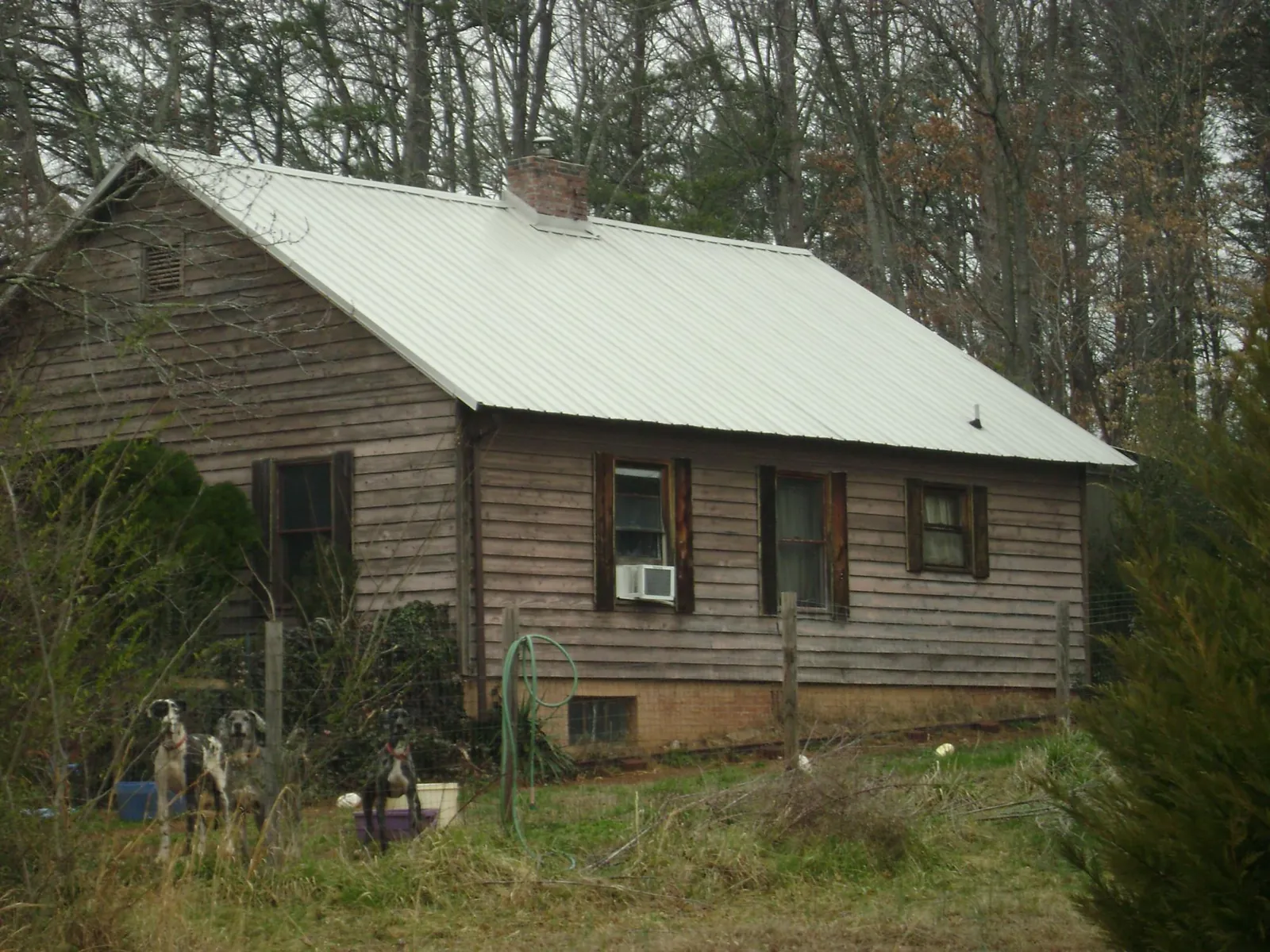 White metal roof on an old wood sided farmhouse, from a Metal Roof Installation job in Black River Falls